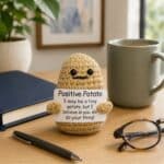A pocket-sized handmade Positive Potato crochet plush holding an encouraging reminder that someone believes in you.