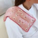 Pretty Floral Heat Pillow Being Used On Shoulder