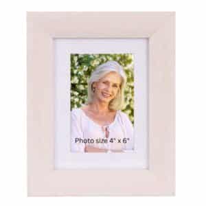 Whitewashed wooden picture frame displaying a 4x6 photo placeholder of a smiling woman outdoors.
