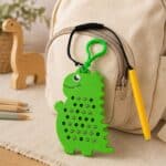 A pocket-sized dinosaur magnetic pad with stylus for reusable tactile bead play.