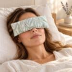 Woman relaxing with a Gumleaf Lavender Eye Pillow resting over her closed eyes on soft neutral bedding