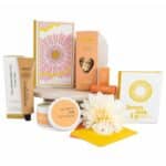Sending Sunshine Self-Care Gift Hamper featuring sunshine candle, notebook, self-care cards, hand cream, lip balm and vanilla biscuits.