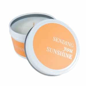 Sending You Sunshine white candle tin with a textured burnt orange label and silver foil lettering
