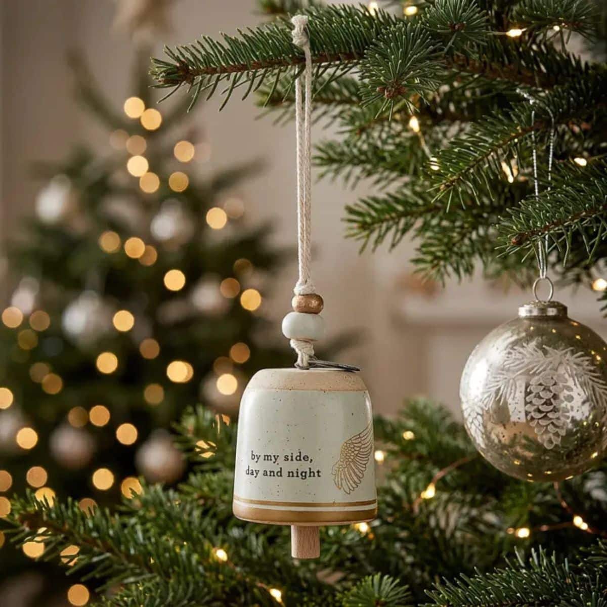 Stoneware Mini Guardian Angel Bell Hanging on a branch of a Christmas Tree